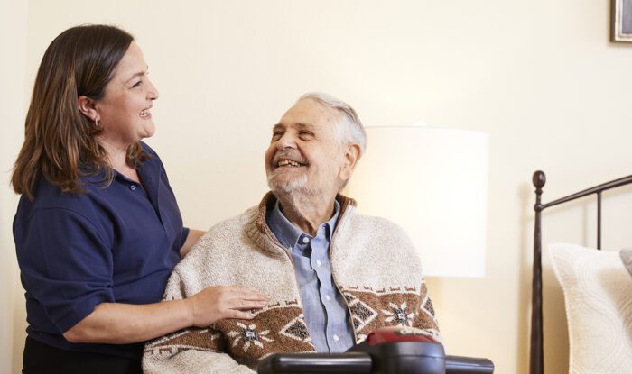 man in wheelchair smiling at nurse