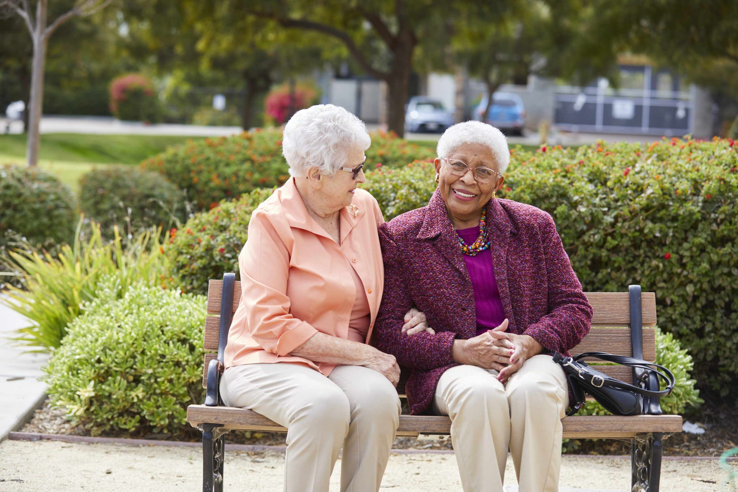 Two women sitting together outside on a bench