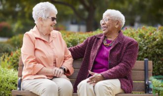 Two women sitting together outside on a bench