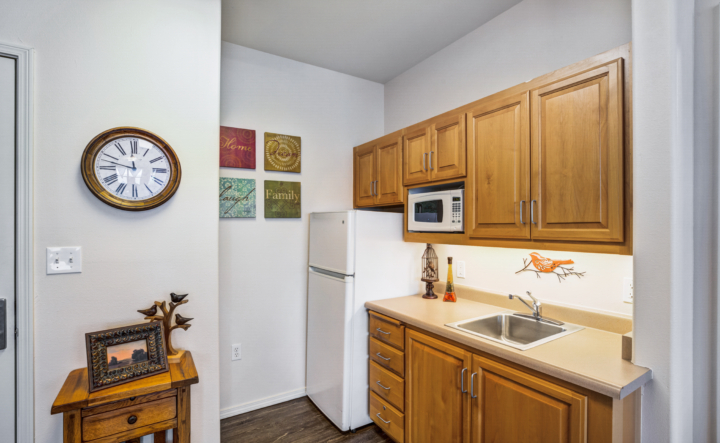 A kitchen with a fridge, microwave and cabinets