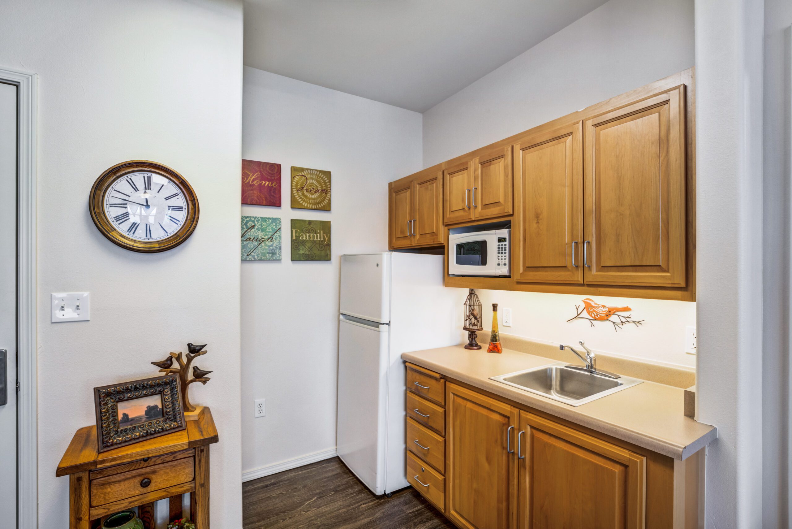 A kitchen with a fridge, microwave and cabinets