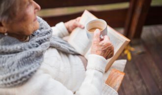 A woman with good cognitive health sits with a cup of tea