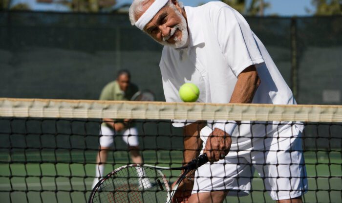 a man gets ready to hit a tennis ball back over the net