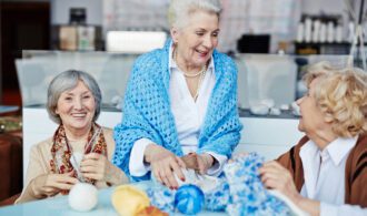 a group of elderly ladies talk about knitting together
