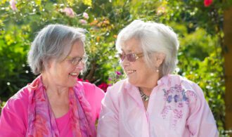 2 elderly women share a smile together