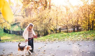 an elderly woman takes her dog for a walk to combat loneliness and isolation