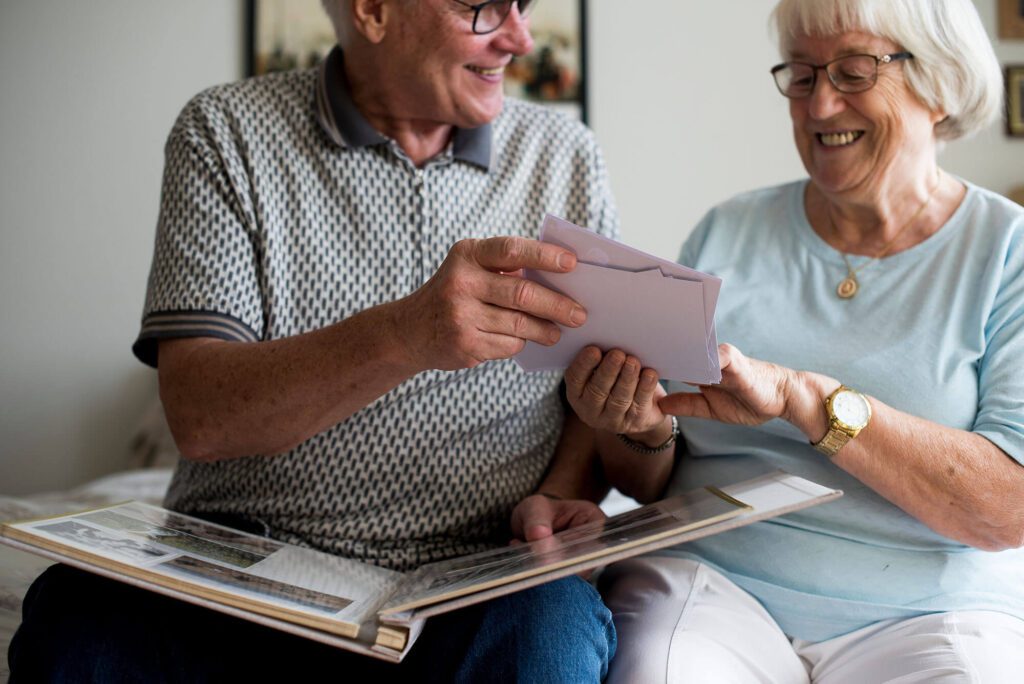 an elderly man shares letters with an elderly woman