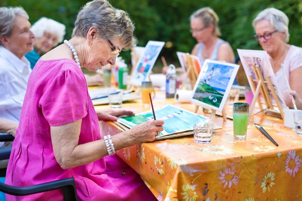 a group of elderly women painting