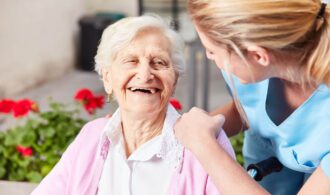 an elderly woman and caretaker share a laugh