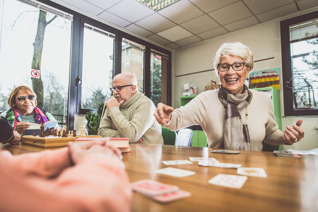 Group Activities: An elderly man and woman playing cards for activity time