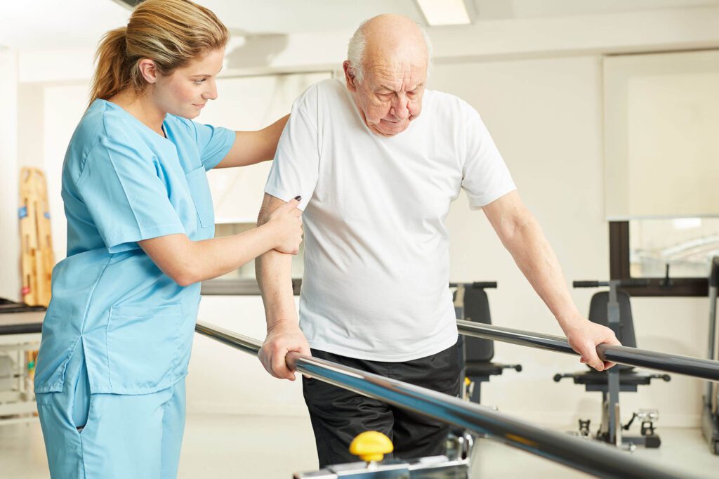 an elderly man has a caretaker help him with physical therapy