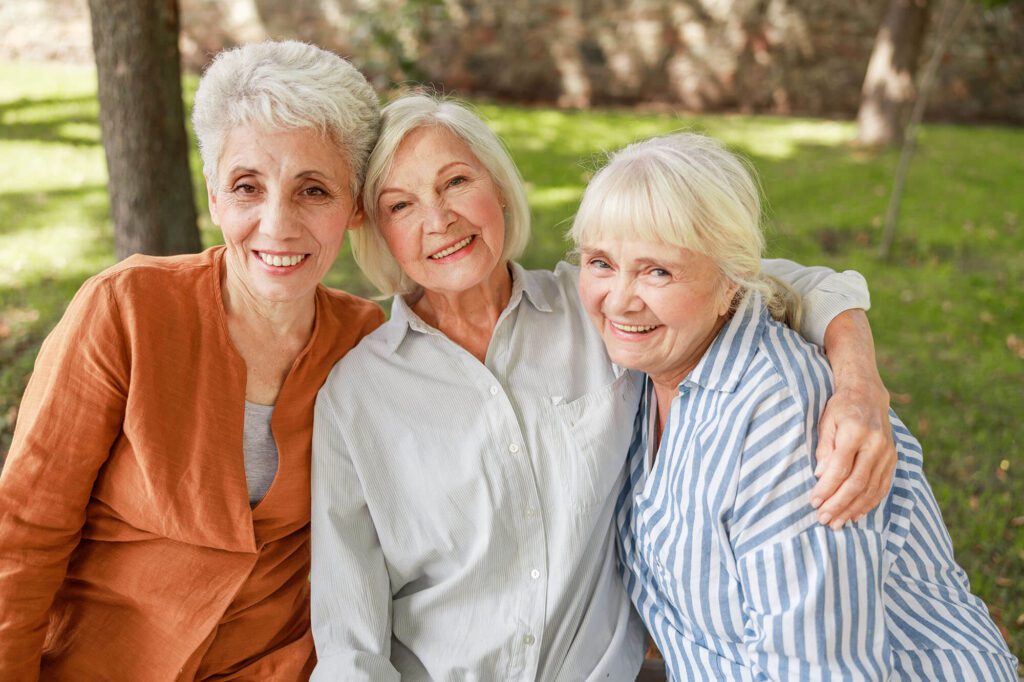 3 elderly woman pose for a photo together