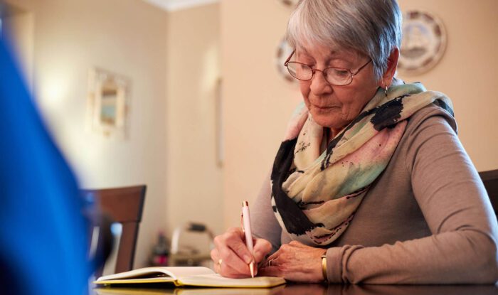 an elderly woman writes in a journal, Assisted Living in National City , California