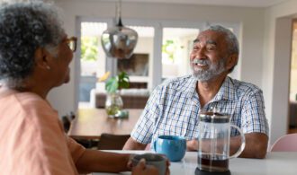 an elderly woman and man share a cup of coffee