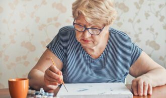 An elderly woman painting