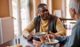 A caregiver enjoying a conversation over a bowl of soup