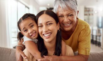 A smiling family of a child parent and grandparent in senior living