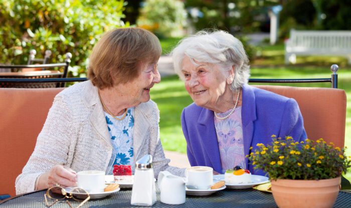 2 elderly woman share a meal and enjoy a conversation