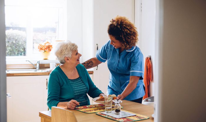 A Generations worker brings a senior citizen breakfast.